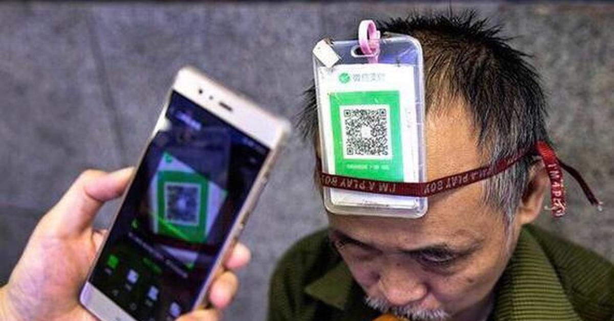 житель Пекина оплачивает покупки с помощью смартфона