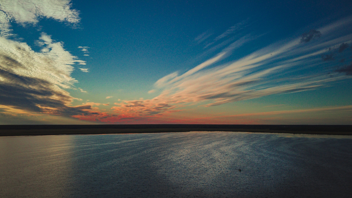 Закат на озере и одинокий рыбак