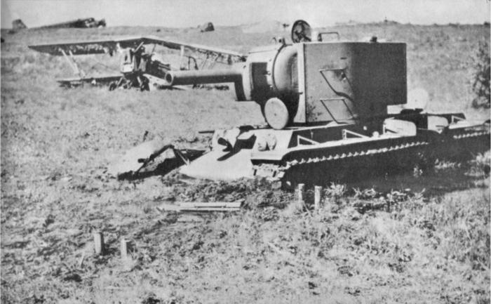 Советский танк КВ-2, завязший в грязи в районе аэродрома. За танком виден уничтоженный советский самолет-биплан (вероятно, Р-5), а ещё дальше немецкий транспортный самолет Юнкерс Ju-52