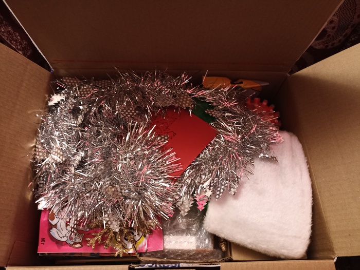 Открыв коробку сразу появилось ощущение праздника, открытка с пожеланиями, мишура, ёлочные игрушки, увидев белую меховушку я решила, что это шапка, но я ошиблась))