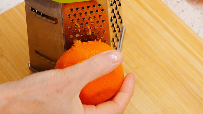 С половины лимона снимаем цедру с помощью мелкой тёрки. И с одного толстокожего мандарина снимаем цедру таким же способом.