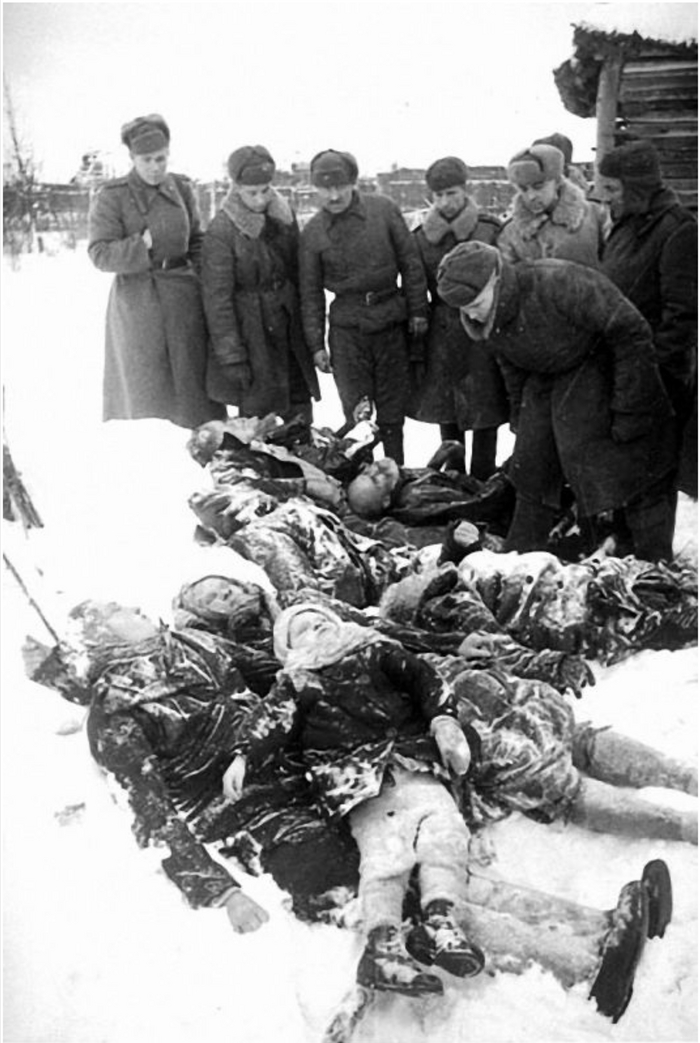 Красноармейцы в освобожденном населенном пункте у тел замученных немцами мирных жителей — женщин, детей, стариков