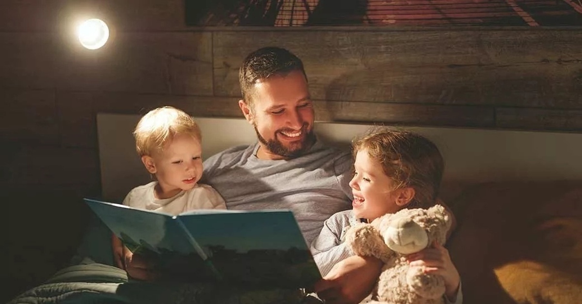 Папа рассказывает сказку. Семейное чтение. Чтение на ночь детям. Семья вечером.
