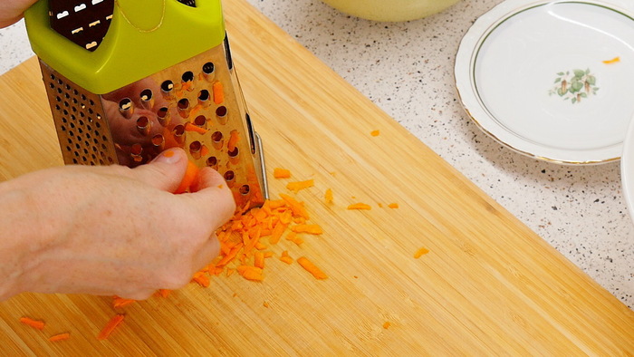 Одну среднюю морковь натираем на крупной тёрке. Складываем к нарезанному луку.