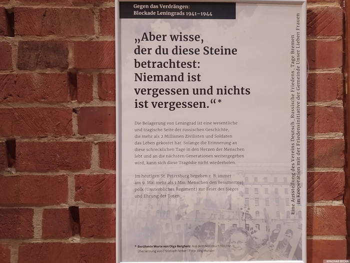 Плакат со словами Ольги Берггольц «Но знай, внимающий этим камням: Никто не забыт и ничто не забыто» на немецком языке