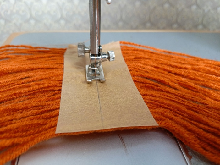 Приклеила посередине каждой части малярный скотч и прошила пряжу самой широкой строчкой.