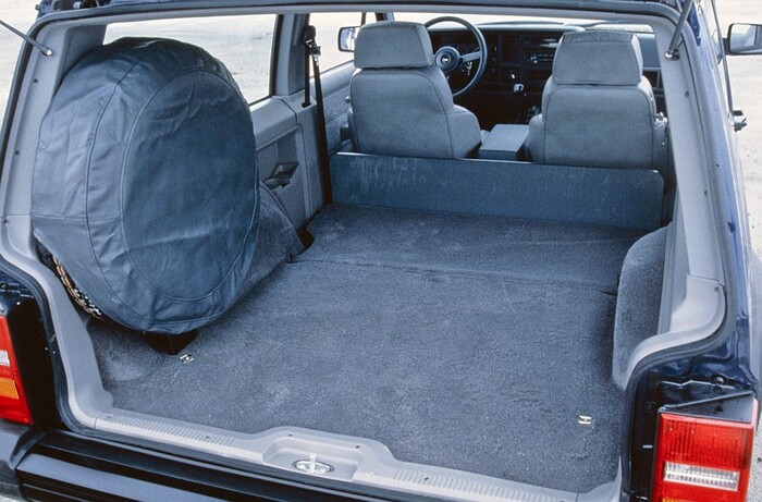 Огромная «запаска» разместилась на левой задней стойке, сокращая полезный объем багажного отделения – место под полом багажника уже было занято бензобаком