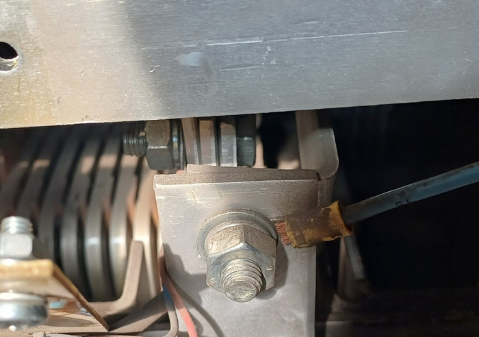 Подлезть надо вон к тому болту, который виднеется за шинами; при чем шейка ключа не пролезает между ними.