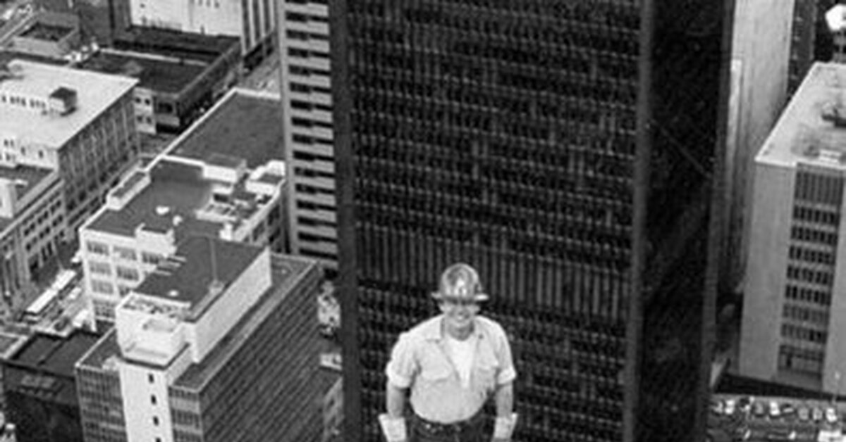 Фотография монтажника металлоконструкций во время строительства башни ...