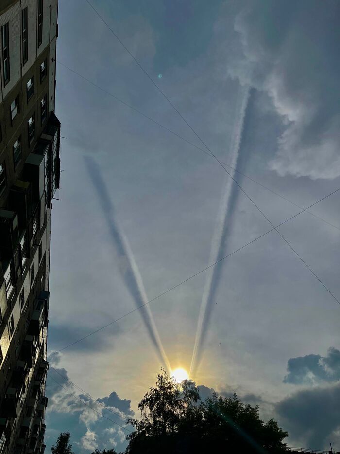 Следы от двух самолётов летящих в аэропорт. И заходящее солнце